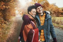 Lächelndes, liebevolles Paar umarmt sich im Herbstpark — Stockfoto