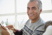 Портрет улыбающийся пожилой человек с помощью цифрового планшета — стоковое фото
