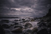 Grandes rochas na tempestuosa praia noturna nublada, Bisserup, Dinamarca — Fotografia de Stock