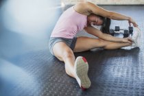 Giovane donna stretching gamba e lato in palestra — Foto stock
