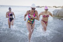 Nuotatrici attive femminili che corrono all'aperto sull'oceano — Foto stock