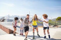 Freunde Rollschuhlaufen im sonnigen Skatepark — Stockfoto