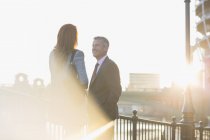 Geschäftsmann und Geschäftsfrau im Gespräch am sonnigen Geländer der Stadt — Stockfoto
