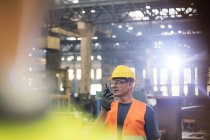 Steel worker using walkie-talkie in factory — Stock Photo