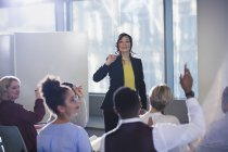 Businesswoman leading meeting, answering audience questions — Stock Photo