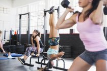 Mujeres jóvenes haciendo ejercicio en el gimnasio juntas - foto de stock