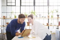 Two young people looking at documents in domestic kitchen — Stock Photo
