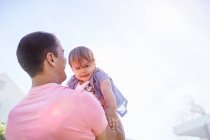 Pai levantando bebê filho lá fora — Fotografia de Stock