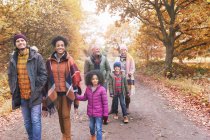 Familia multigeneracional caminando por el camino en el parque de otoño - foto de stock