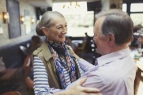 Affectueux couple de personnes âgées câlins dans le bar — Photo de stock