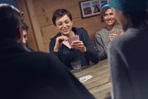 Amis jouer aux cartes à la table de cabine — Photo de stock