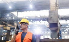Stahlarbeiter benutzt Walkie-Talkie in Fabrik — Stockfoto