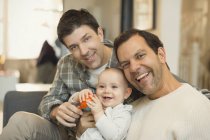 Portrait male gay parents holding cute baby son — Stock Photo