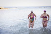 Жіночі активні плавчині, що біжать на відкритому повітрі в океані — стокове фото