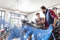 Mécanique moto homme et femme réparer moto en atelier — Photo de stock