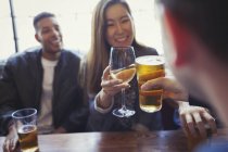 Друзі святкування, тост пива й вина на стіл в барі — стокове фото