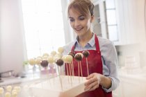 Lächelnde Catererin backt Cake Pops in Küche — Stockfoto