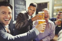 Захоплені чоловіки друзі тости пивні окуляри в барі — стокове фото