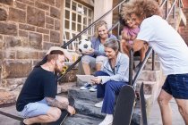 Friends hanging out using digital tablet on urban steps — Stock Photo