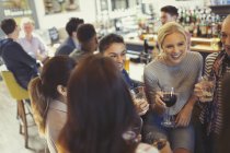 Women friends drinking and talking at bar — Stock Photo