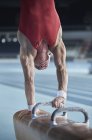 Male gymnast performing upside-down handstand on pommel horse — Stock Photo