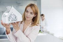 Arquiteta feminina examinando modelo no escritório — Fotografia de Stock