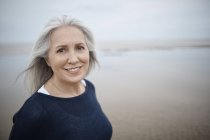 Retrato sorrindo mulher idosa na praia — Fotografia de Stock