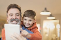 Vater und Sohn verbinden sich und teilen sich ein digitales Tablet — Stockfoto