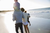 Família feliz andando na praia — Fotografia de Stock