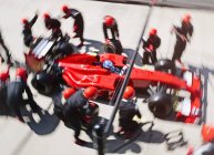 Overhead pit crew replacing tires on formula one race car in pit lane — Stock Photo