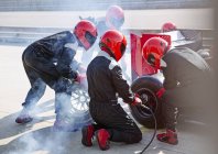 Boxencrew tauscht Reifen an Formel-1-Rennwagen in Boxengasse aus — Stockfoto
