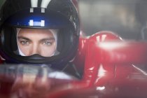 Close up focused formula one race car driver in helmet looking away — Stock Photo
