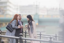 Business people drinking coffee and talking on urban ramp — Stock Photo