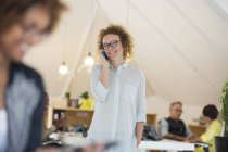 Портрет жінки, що розмовляє по телефону в сучасному офісі — стокове фото