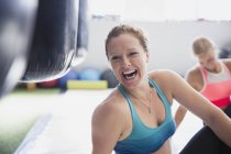 Retrato rindo boxeador feminino se alongando no ginásio — Fotografia de Stock