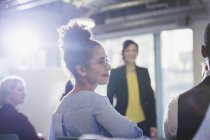 Businesswoman turning, listening in conference audience — Stock Photo