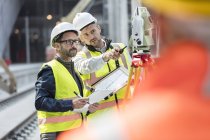 Інженери-чоловіки, які використовують теодоліт на будівельному майданчику — стокове фото