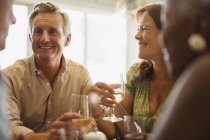Lachendes älteres Paar trinkt Wein am Restauranttisch — Stockfoto