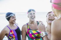 Mulheres nadadoras ativas sorrindo para o oceano ao ar livre — Fotografia de Stock