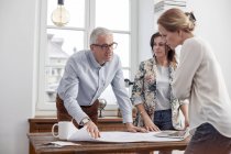 Architects reviewing, discussing blueprints in conference room meeting — Stock Photo