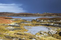 Sunny tranquil view craggy rocks and lake, Loch Euphoirt, North Uist, Outer Hebrides — Stock Photo