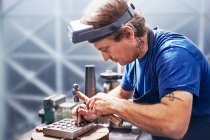 Juwelier mit Hammer in Werkstatt — Stockfoto