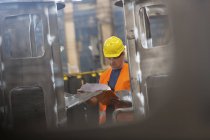 Travailleur de l'acier examinant la paperasserie en usine — Photo de stock