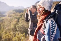 Young couple hiking, looking at sunny view with binoculars — Stock Photo