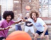 Personal perspective friends playing basketball at urban basketball court — Stock Photo
