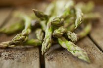 Still life close up fresh, organic, healthy, green asparagus tips on wood — Stock Photo