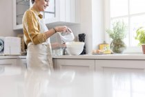 Donna cottura, utilizzando miscelatore elettrico mano in cucina — Foto stock