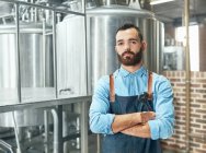 Portrait confident male brewer in front of vat in brewery — Stock Photo