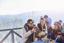 Snowboarder and skier friends drinking cocktails on balcony apres-ski — Stock Photo