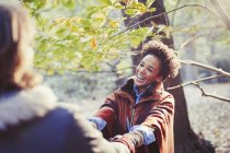 Happy woman holding hands with boyfriend in sunny autumn park — Stock Photo